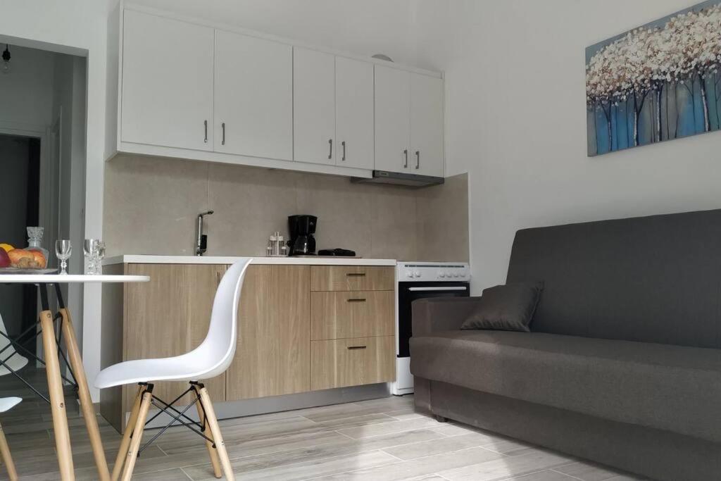 a kitchen with a couch and a table and a chair at Iliaktis Cozy & Quiet Apartment in Heraklio Town