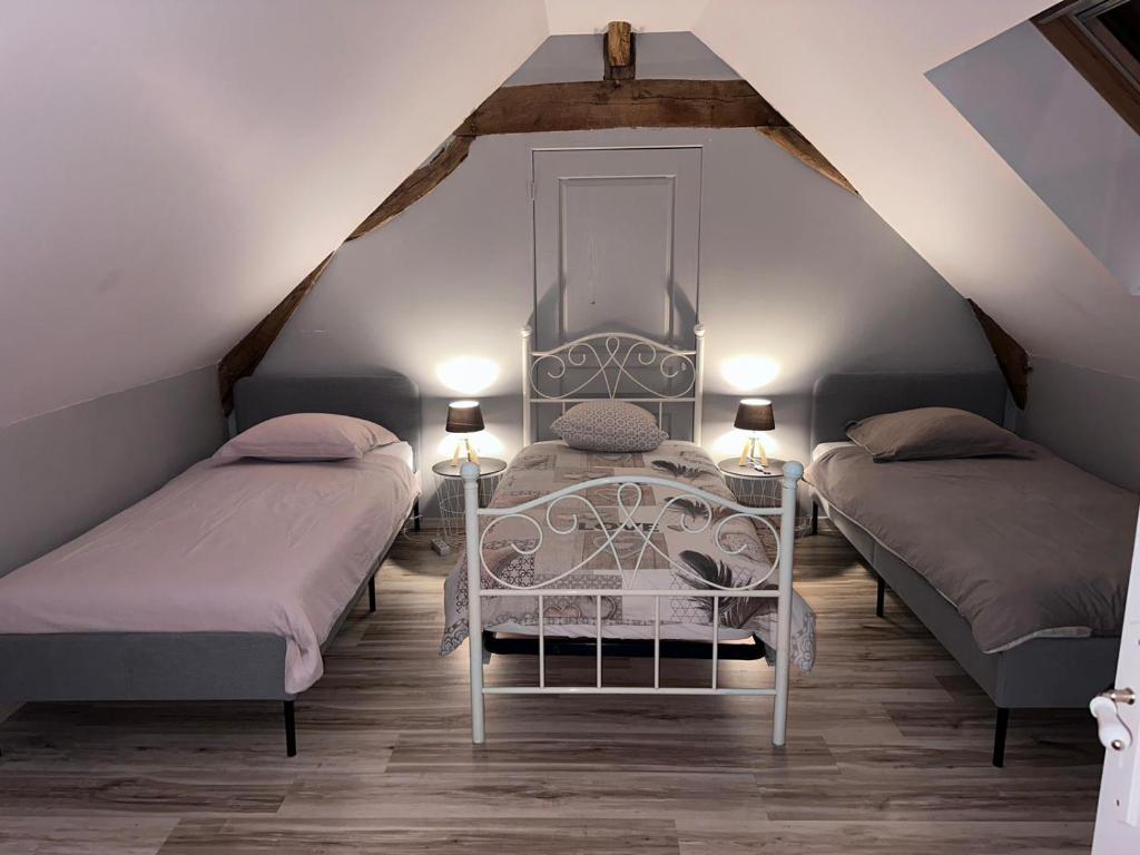 1 dormitorio con 2 camas en un ático en Gîte la grande racinaie, en Cré-sur-Loir