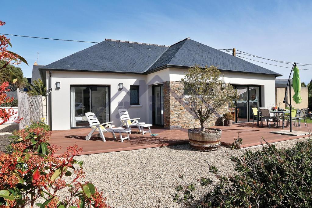 ein Haus mit zwei weißen Stühlen auf einer Terrasse in der Unterkunft LocaLise - M11 - Ty Gwennili - Maison de plain pied avec terrain entièrement clôturé - Accès plage et centre à pied - Wifi inclus - Draps inclus - Animaux non admis in Le Guilvinec