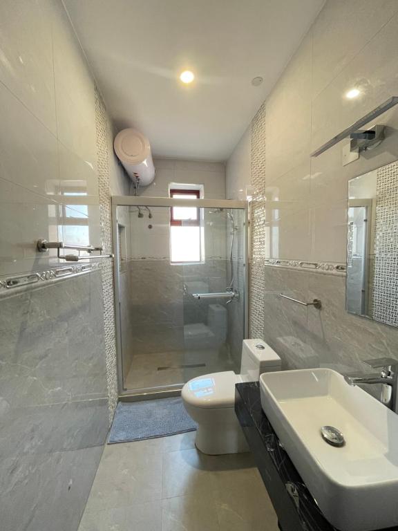 a bathroom with a shower and a toilet and a sink at Keitylin Heights Apartments in Makindye in Kampala