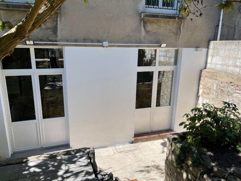a white garage door with windows on a building at Au Beau Duplex de la Basilique in Boulogne-sur-Mer