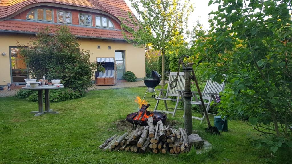 una hoguera en un patio frente a una casa en Ferienhaus Leuchtfeuer - Buchungen ab 4 Übernachtungen, en Putgarten