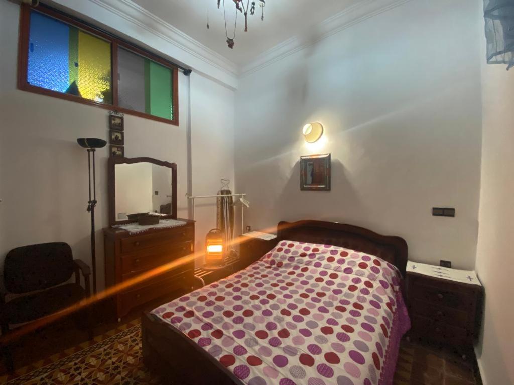 1 dormitorio con cama, tocador y espejo en Appartement meublé 5 personnes en plein centre ville, en Rabat