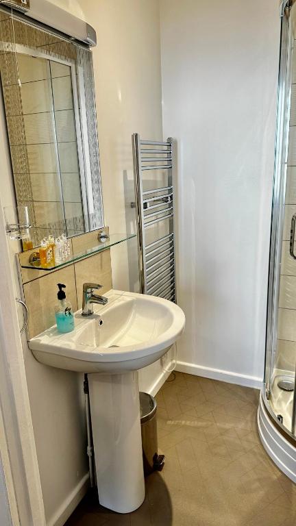 a white bathroom with a sink and a shower at Andorra Guest Accommodation in Brighton & Hove