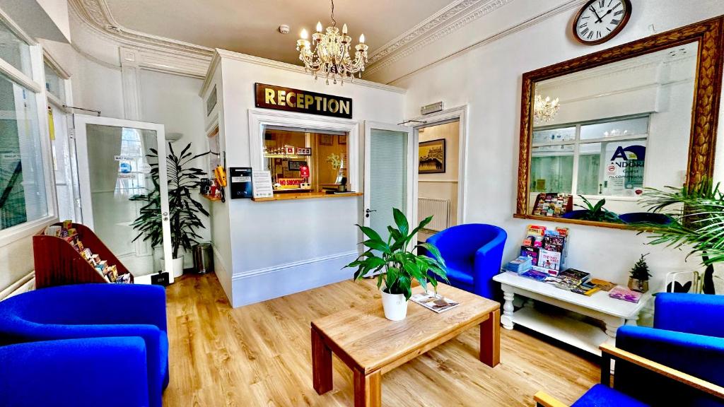 a waiting room with blue chairs and a table at Andorra Guest Accommodation in Brighton & Hove
