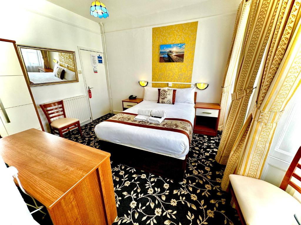 a hotel room with a bed and a desk at Andorra Guest Accommodation in Brighton & Hove