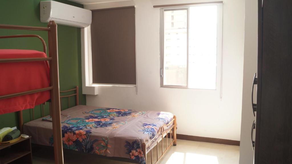 Dormitorio pequeño con litera y ventana en Remodeled Downtown Apartment - Centro de Guayaquil, en Guayaquil