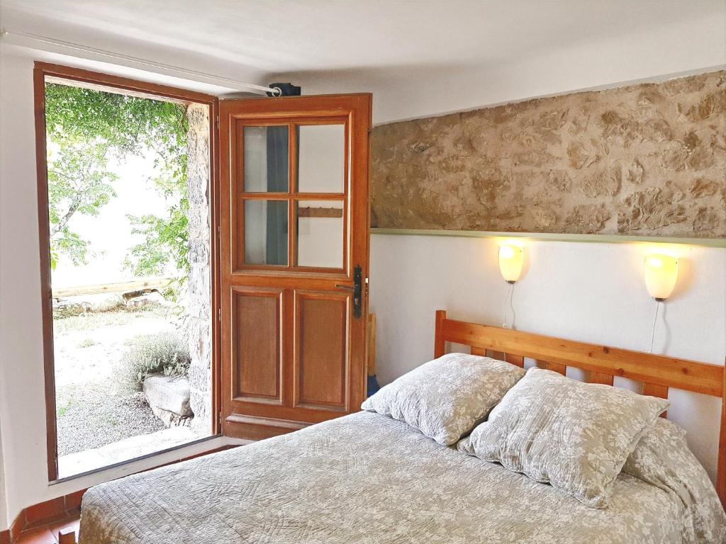 een slaapkamer met een bed en een raam bij Un cadre magnifique, au cœur du Verdon in Castellane