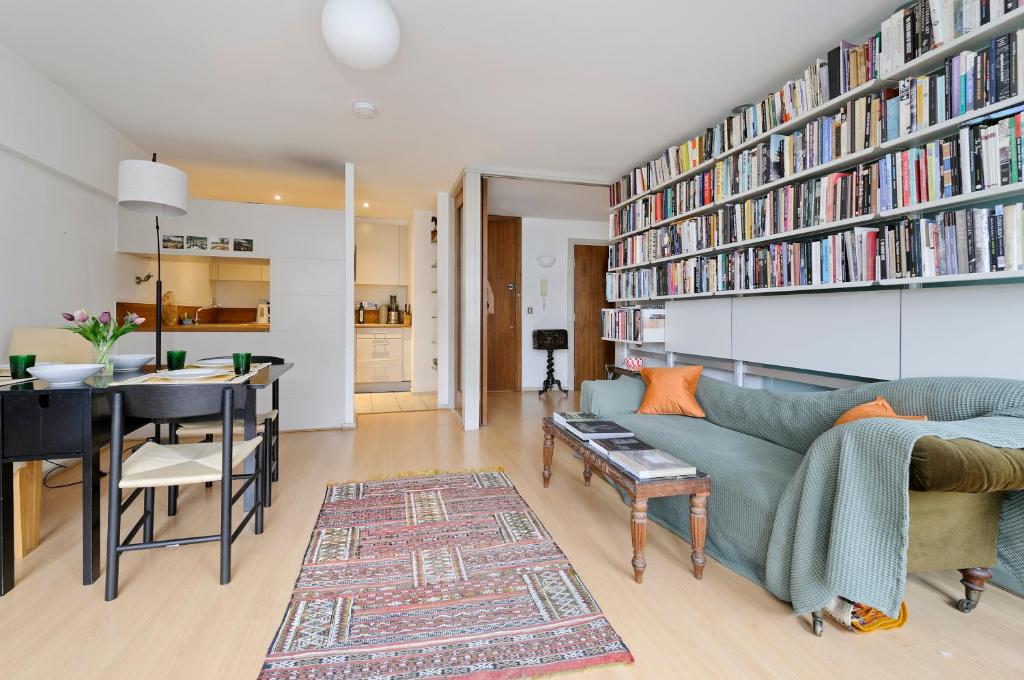 sala de estar con sofá y comedor en Large one bedroom flat with balcony close to the City by UnderTheDoormat en Londres
