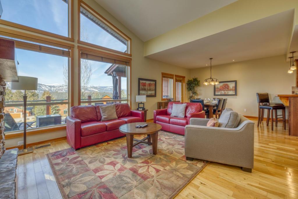 ein Wohnzimmer mit roten Möbeln und einem großen Fenster in der Unterkunft The Residences at Fairmont Ridge in Fairmont Hot Springs