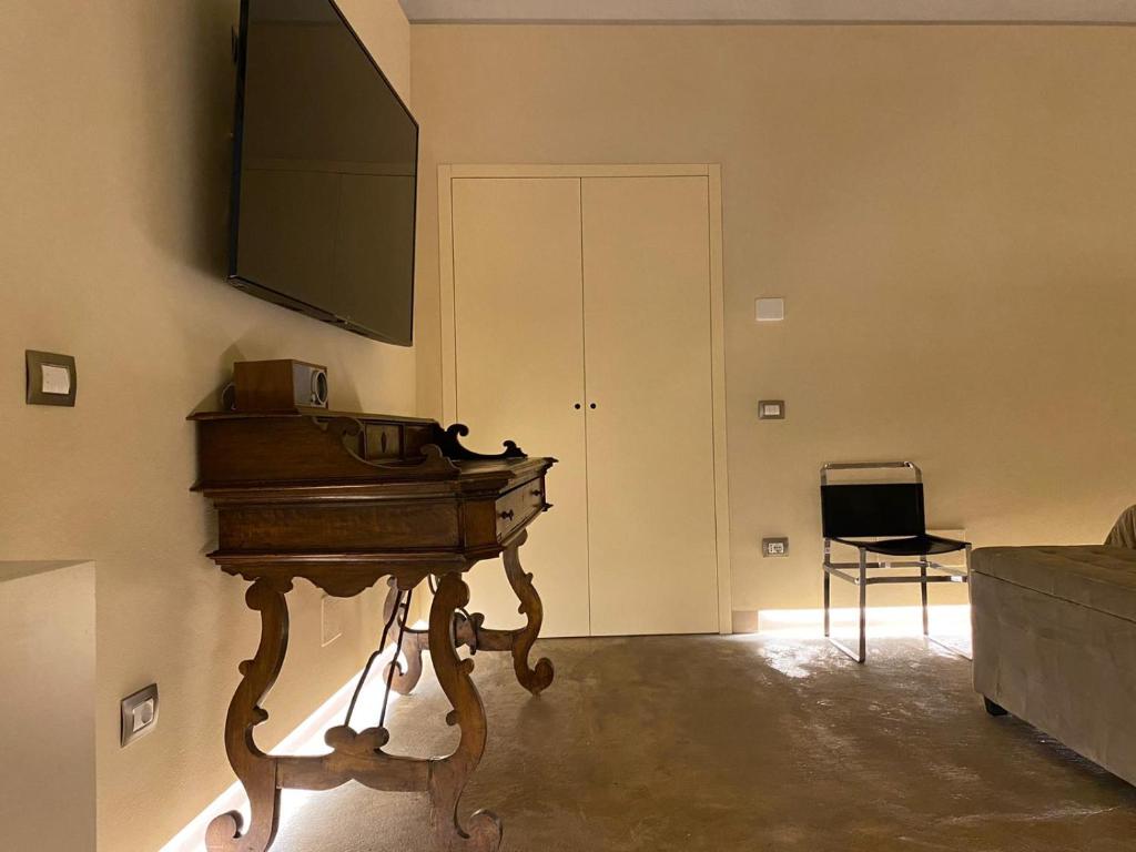 un soggiorno con pianoforte e TV a schermo piatto di Suite di Bianca a Foligno