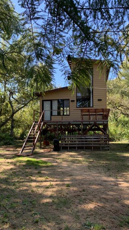 a small house with a porch and a porch swing at Cabaña Los Lirios in Tigre