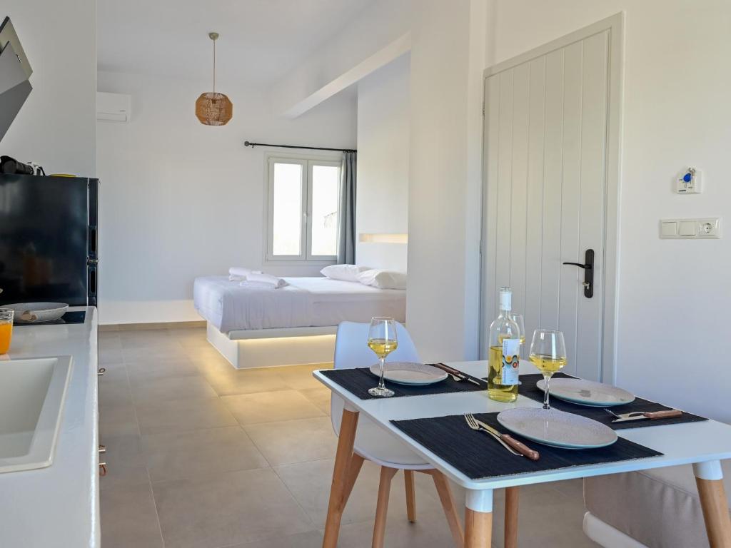 uma cozinha e sala de estar com uma mesa com copos de vinho em Oliva Naxos Apartments em Naxos Chora