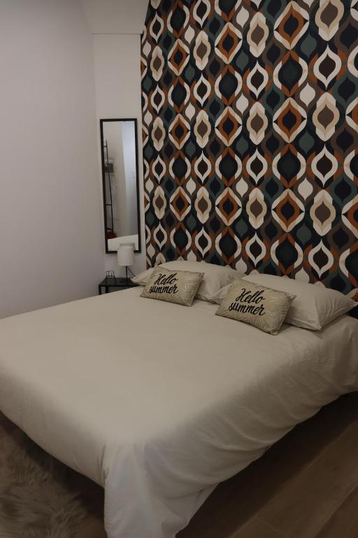 a white bed with two pillows and a wall at U cuttigghiu in Catania