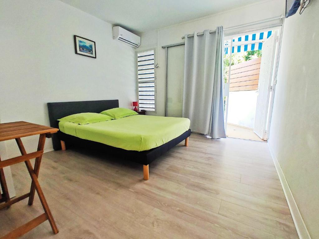 une chambre avec un lit et un parquet dans l'établissement Location proche plage, au Gosier