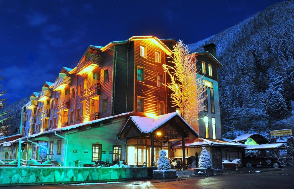 un grande edificio nella neve di notte di Inan Kardesler Hotel a Uzungöl