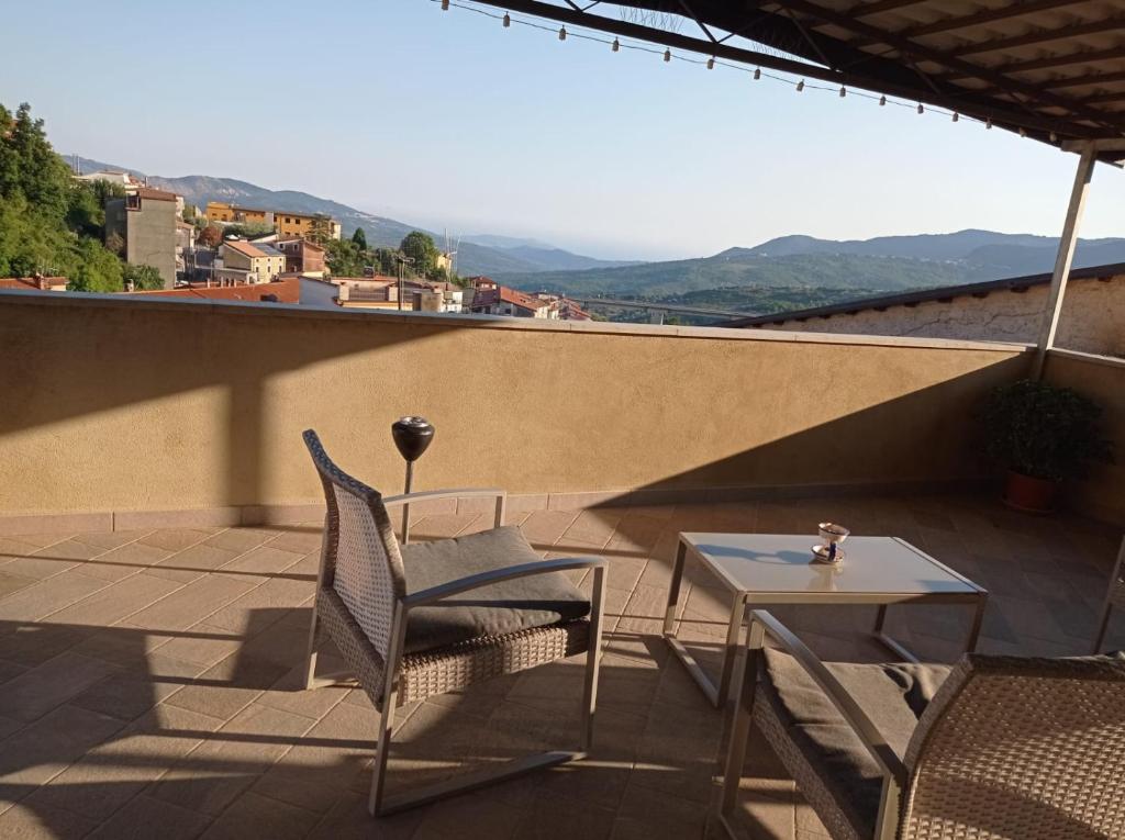 eine Terrasse mit 2 Stühlen und einem Tisch auf dem Dach in der Unterkunft Casa Torre con terrazza panoramica in Futani