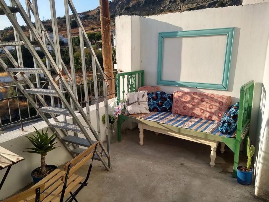 een bank op een veranda met een ladder bij The Village House in Kerames