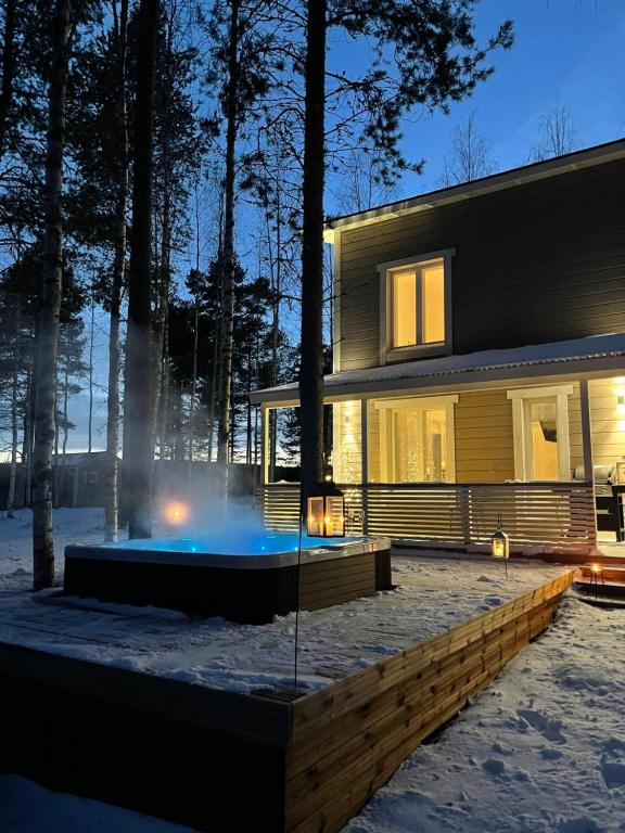 uma casa com uma fonte em frente em Luxurious Villa Snow with Jacuzzi em Rovaniemi