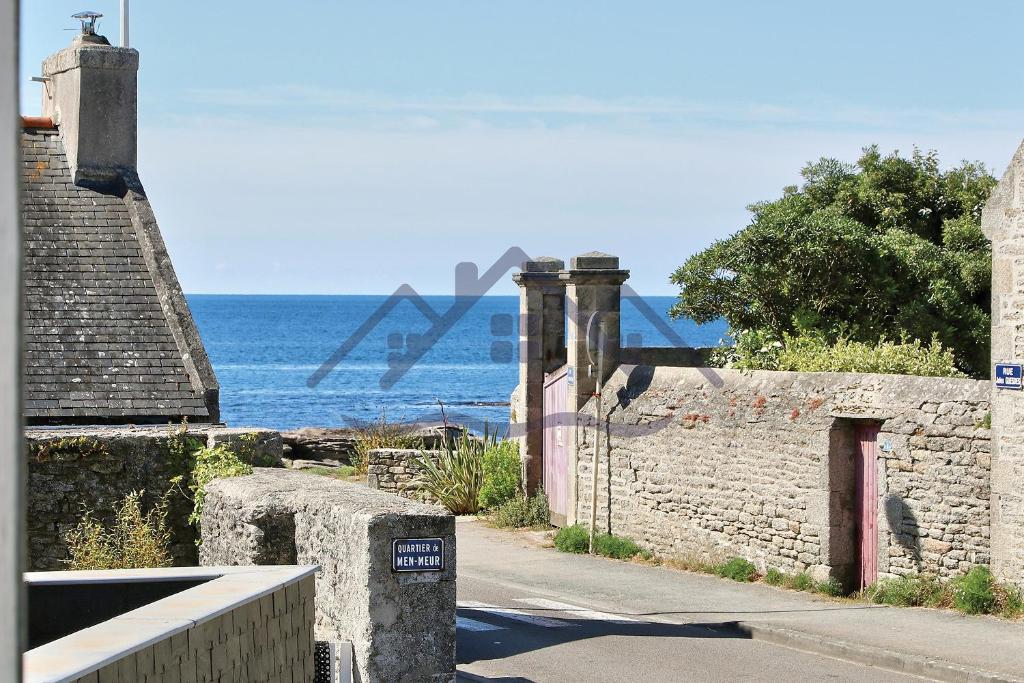 eine Steinmauer mit dem Ozean im Hintergrund in der Unterkunft LocaLise - M3A La Maison du pêcheur au Guilvinec - Chambres vue mer - A 20m de la mer située à la pointe de Men Meur - Tout à pied, plage, port, centre, commerces, marché - Wifi inclus - Linge de lit inclus - Jardin clos - En option , ménage et serviettes in Le Guilvinec