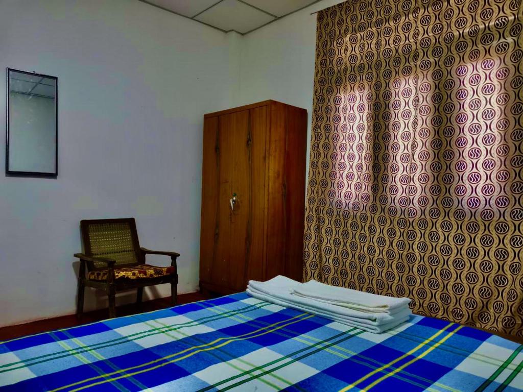 康提的住宿－Kandy River Reach -Home Stay，卧室配有床、椅子和窗户。
