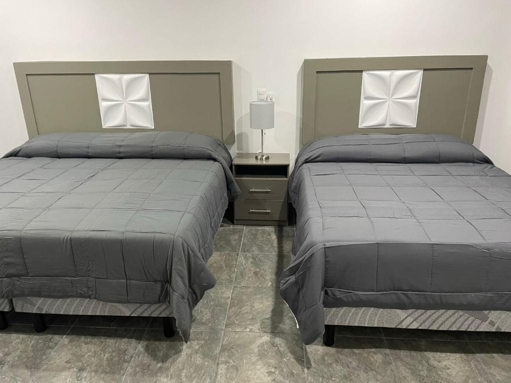 - 2 lits installés l'un à côté de l'autre dans une chambre dans l'établissement Posada 53, à Mazatlán