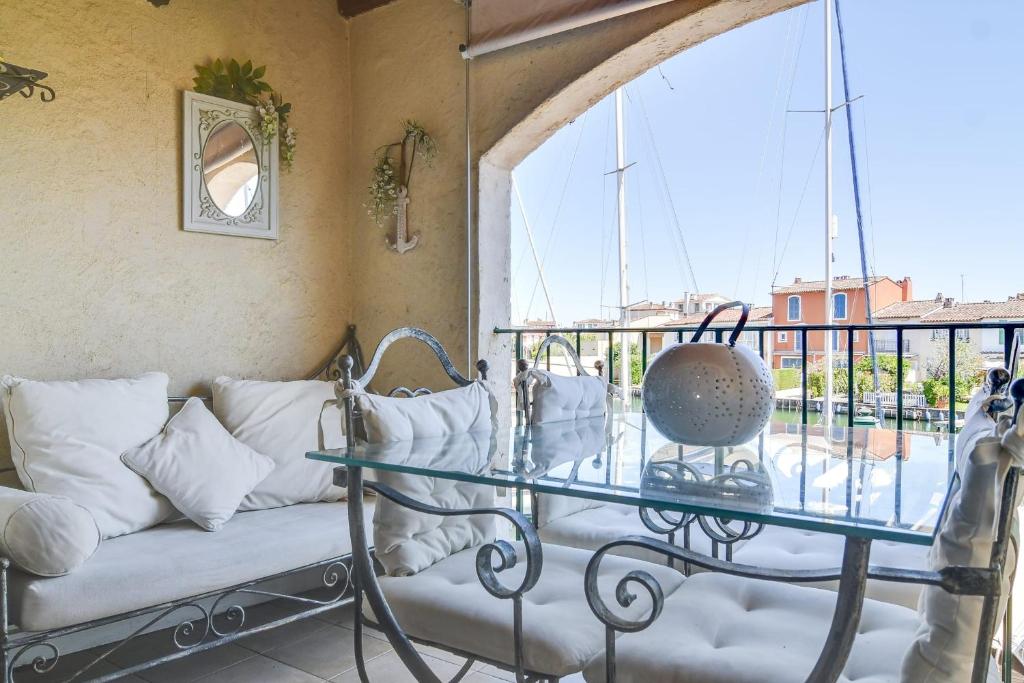 a room with a couch and a glass table on a balcony at Studio With Balcony Overlooking The Port in Grimaud