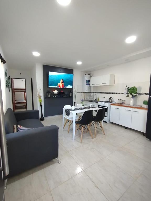 a living room with a couch and a table and a kitchen at El Temple Timperio in San Clemente del Tuyú