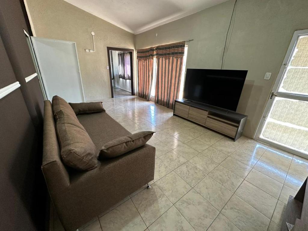 Una sala de estar con un sofá y un televisor de pantalla plana. en Depto XL Villa Unión, en Villa Unión