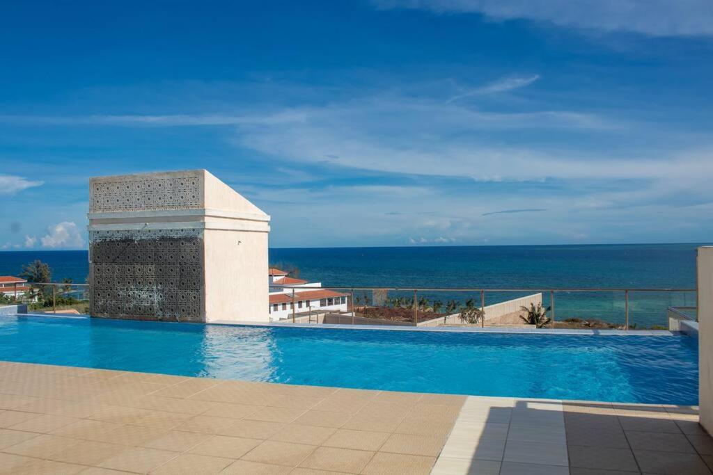 a swimming pool with a view of the ocean at A Cozy 3 Bed Apartment With a Swimming Pool in Nyali - Beach Front in Mombasa