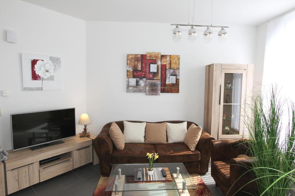 sala de estar con sofá y TV de pantalla plana en Cityloft, en Ypres