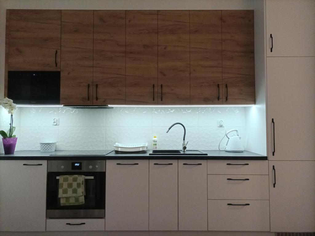 a kitchen with white cabinets and a sink at Apartament Zielone Tarasy in Rzeszów