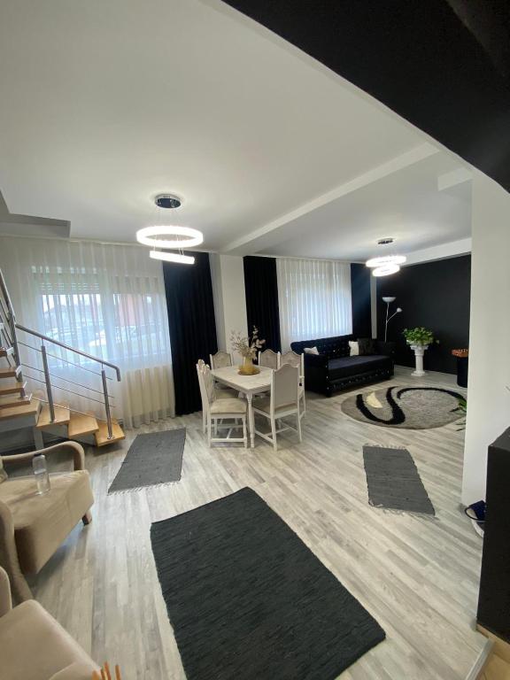 een woonkamer met een bank en een tafel en stoelen bij Vila CCC in Oradea