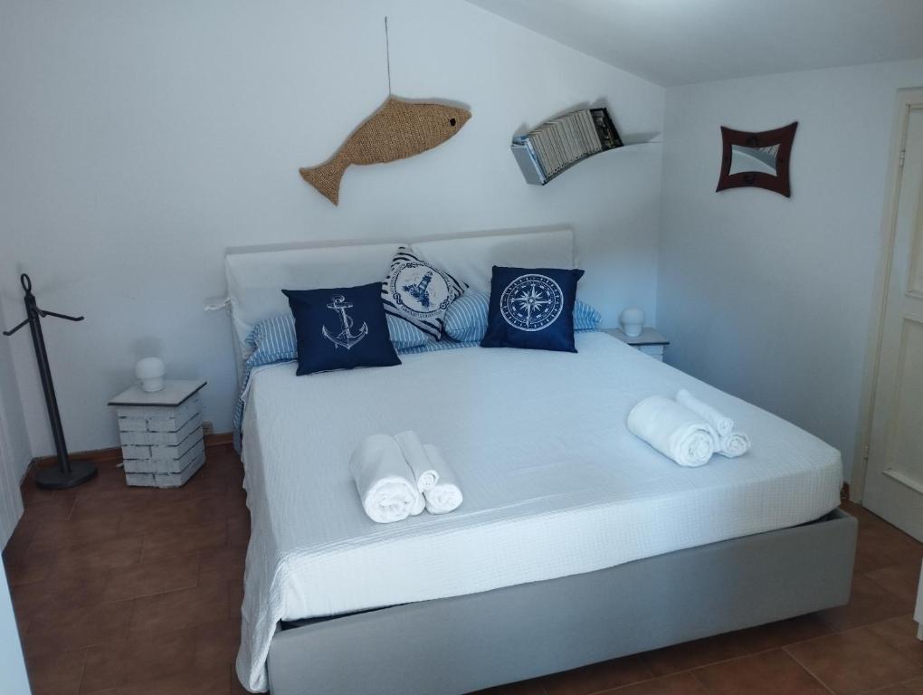 Il glicine Marina Romea في مارينا روميا: غرفة نوم بسرير ابيض مع مخدات زرقاء
