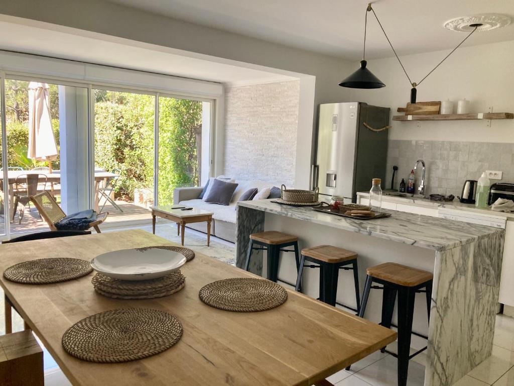 a kitchen and living room with a table and chairs at Les Restanques Maison 26 pinède 3 chambres in Grimaud