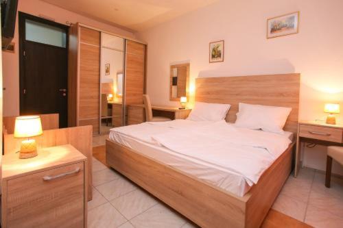 a bedroom with a large bed with a desk and a room with at Lovely Home City Center in Mostar