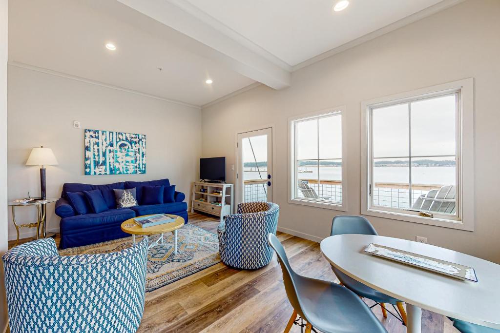 a living room with a blue couch and a table and chairs at Penn Cove Strand #F in Coupeville