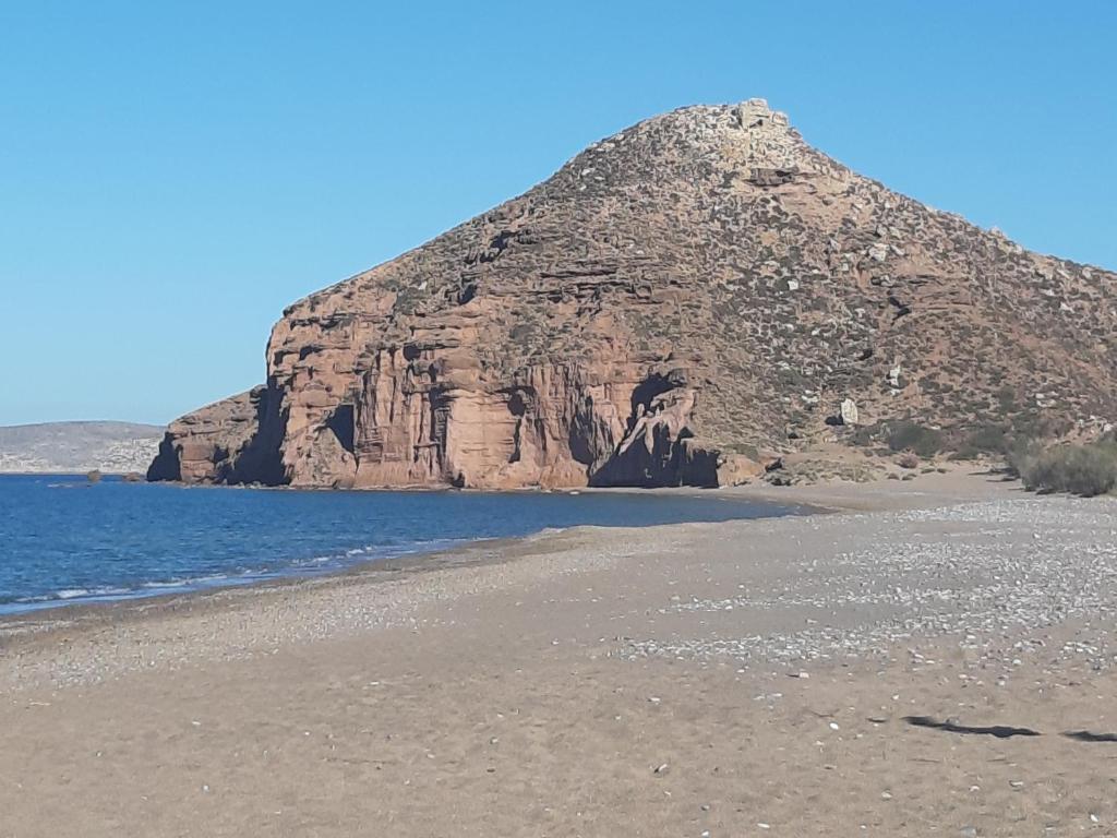 a large mountain sitting on top of a beach at LILIUM HOUSE PALEKASTRO in Palekastron