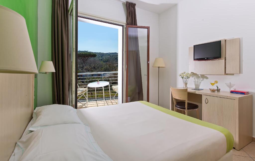 a hotel room with a large bed and a balcony at De Maria House in SantʼAgata sui Due Golfi