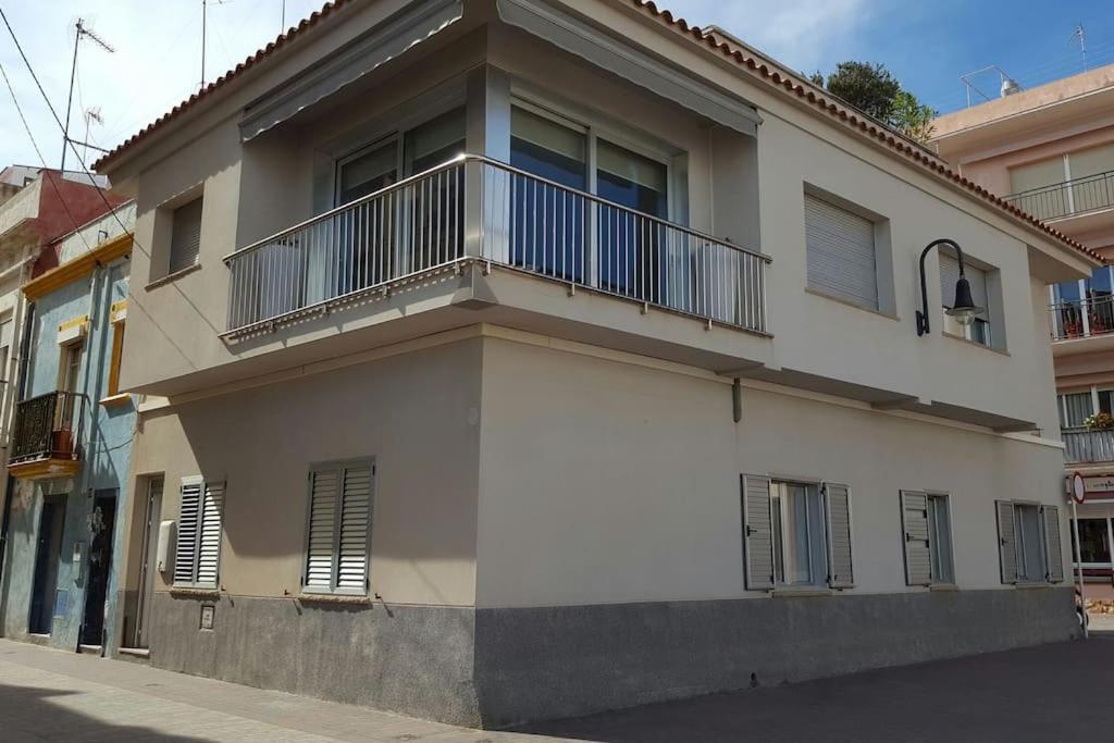 a white building with a balcony on a street at Increíble casa frente al mar , planta baja in Torredembarra