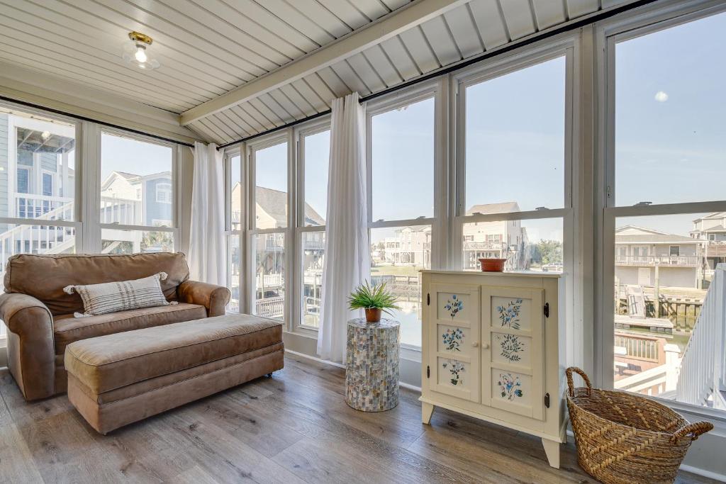 a living room with a couch and large windows at Holden Beach Home on Intracoastal Waterway Canal! in Holden Beach