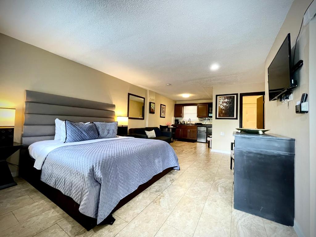 a bedroom with a bed and a living room at Sheridan Suites Apartments in Dania Beach