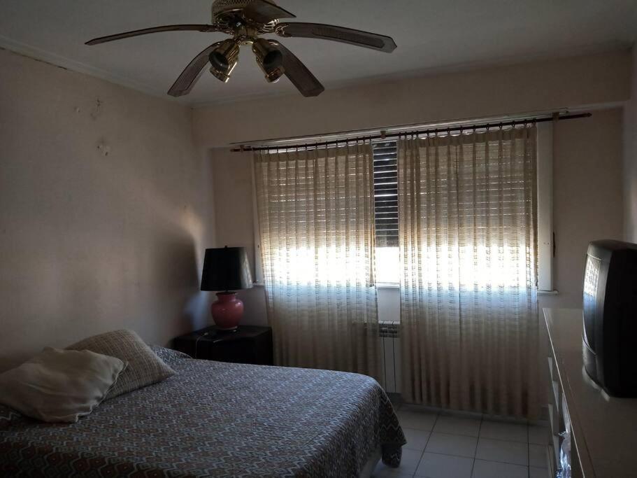 a bedroom with a bed and a ceiling fan at Departamento al frente- Habitación con living in Tandil