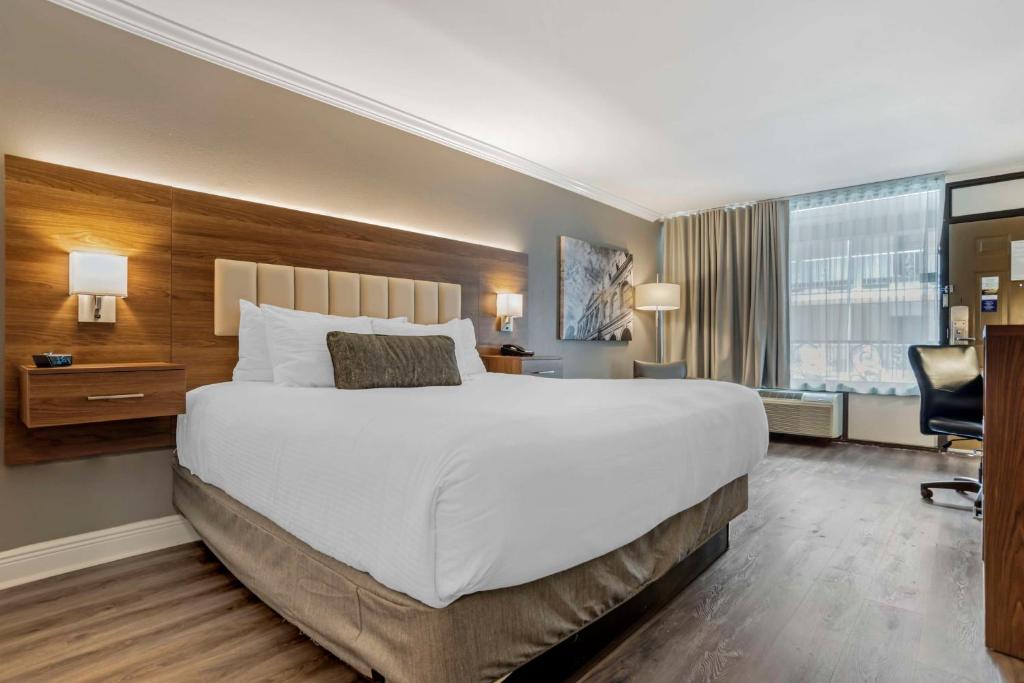 a hotel room with a large bed and a desk at Best Western Plus Westbank in Harvey
