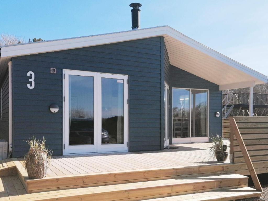 uma pequena casa azul com um deque de madeira em 8 person holiday home in Vestervig em Vestervig