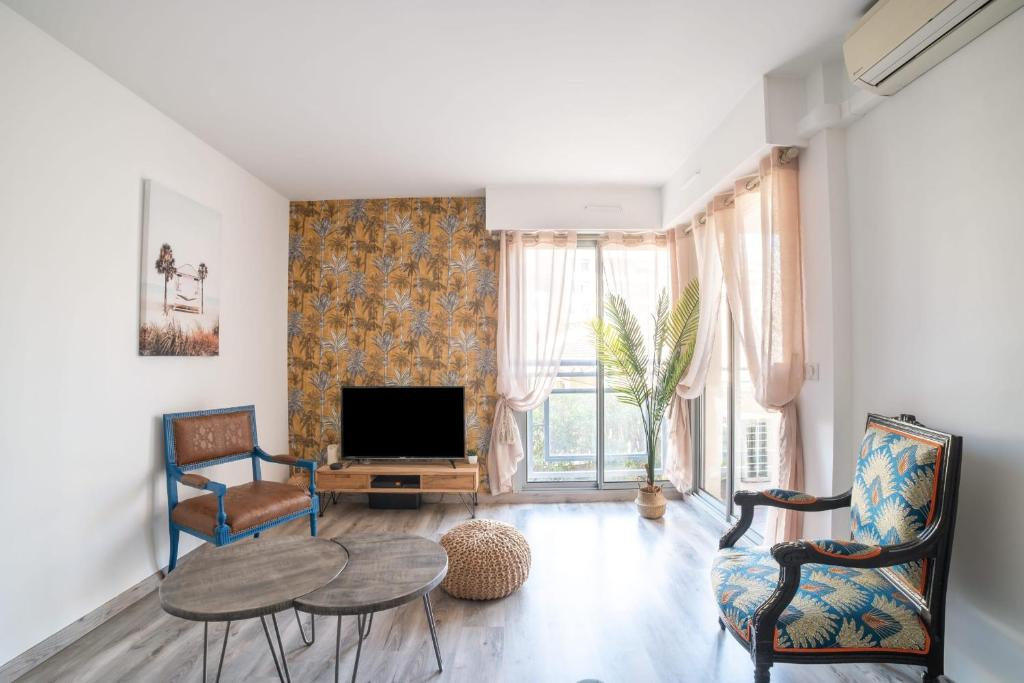 - un salon avec une table, des chaises et une télévision dans l'établissement Bright 66m At 600m From The Center Of Cannes, à Cannes