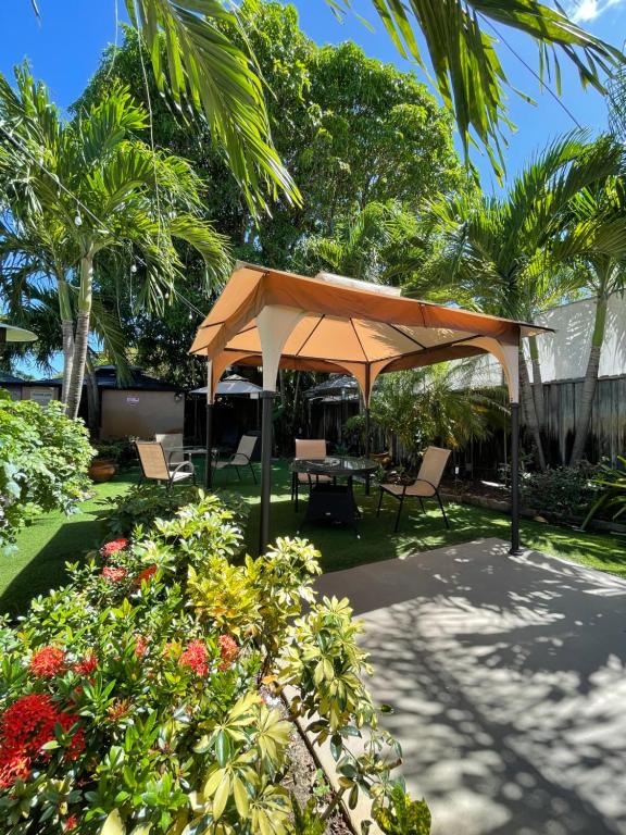a pavilion with a table and chairs in a garden at Sheridan Hostel in Dania Beach