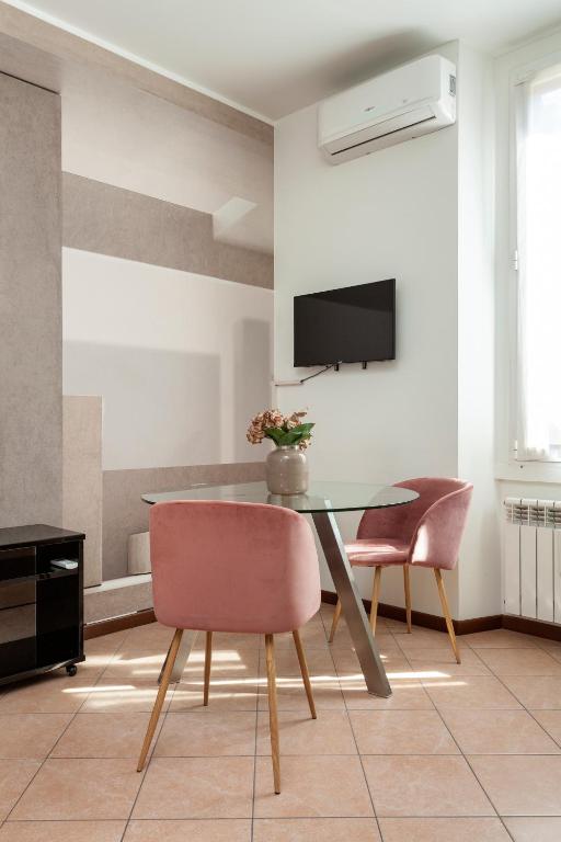 jadalnia ze szklanym stołem i dwoma krzesłami w obiekcie Exquisite Stay Vannucci- Porta Romana w Mediolanie