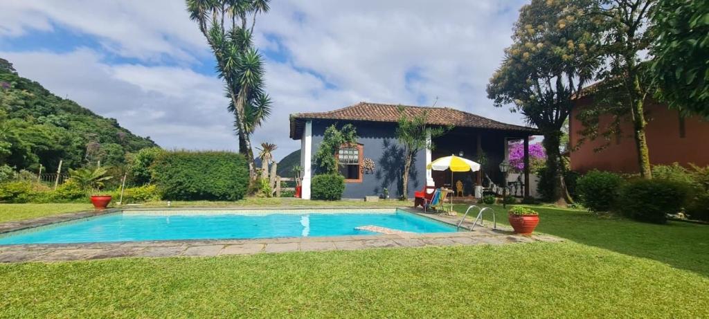 a swimming pool in the yard of a house at Casa Temporada com Tranquilidade e Aconchego - Petrópolis - RJ in Petrópolis