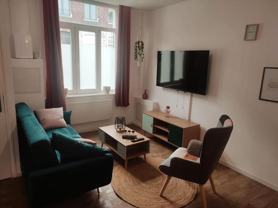 sala de estar con sofá y TV en Maison scandinave avec garage, en Roubaix